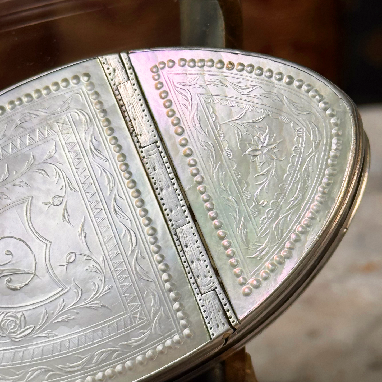 An antique oval tortoiseshell, mother-of-pearl, and silver snuff box, placed in a miniature jewelry box, close up of details on mother-of-pearl lid