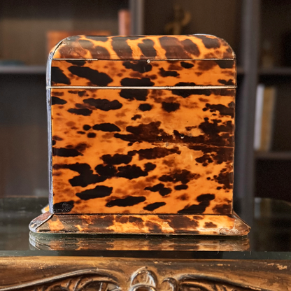 Tortoiseshell-patterned box on a reflective surface with a blurred background